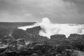 Brimketill lava rock pool in Iceland huge wave hitting black basalt coast in black and white