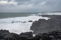 Brimketill lava rock pool in Iceland storm waves hitting black basalt rock