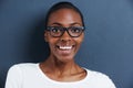 Brimming with energy. Portrait of a happy and attractive young woman wearing glasses on a gray background. Royalty Free Stock Photo