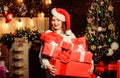 Bring magic into someone elses life. Lady santa celebrate christmas at home. Girl stylish makeup red lips hold many