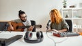 Bring music to life. Man playing guitar and woman smiling, playing rhythm with djembe drum. Couple of musicians