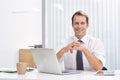 Bring a smile to work day. Portrait of a handsome and confident young businessman sitting at his office desk. Royalty Free Stock Photo