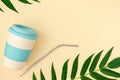 Bring your own cup concept. Bamboo eco cup and metal drinking straw on beige background. Copy space