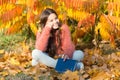 Bringing school into nature. Cute primary school child with book sit on yellow leaves. Happy little girl back to school