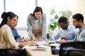 Bringing their ideas to the table. an attractive young businesswoman addressing her colleagues during a meeting in the Royalty Free Stock Photo