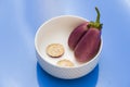 Brinjal aubergines slice pieces on white cup isolated blue background