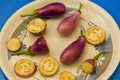 Brinjal aubergines slice pieces on white cup blue background