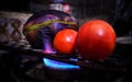 Brinjal or eggplant and tomatoes are being roasted on the fire flame of the gas stove.
