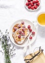 Brioche french toast with raspberry, powdered sugar and green tea. Cozy home still life, free time rest. On a light background, to Royalty Free Stock Photo