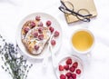 Brioche french toast with raspberry, powdered sugar and green tea. Cozy home still life, free time rest. On a light background, to Royalty Free Stock Photo