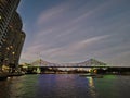 BRISBANE, AUSTRALIA - JULY 10, 2020: Twilight scene of famous Story Bridge and City Cat ferry in Brisbane River with high-rise Royalty Free Stock Photo