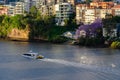 Brisbane City Cat ferry sails past houses and apartments on Bribane River Royalty Free Stock Photo