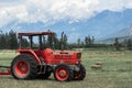 Farm tractor in a hay field against the Rocky Mountains Royalty Free Stock Photo