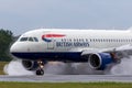 British Airways Airbus A318-112 aircraft G-EUNB landing on the wet runway with reverse thrust spraying water Royalty Free Stock Photo
