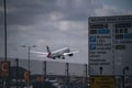 British Airways Boeing plane takes off from the airport on cloudy sunny day