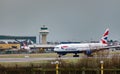 A British Airways plane taxis after landing at London Gatwick Airport, with the air traffic control tower in the background Royalty Free Stock Photo