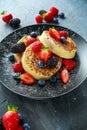 British Crumpets breakfast with blueberries, strawberries, blackberries, raspberries drizzled with icing sugar Royalty Free Stock Photo