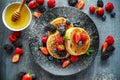 British Crumpets breakfast with blueberries, strawberries, blackberries, raspberries drizzled with icing sugar Royalty Free Stock Photo