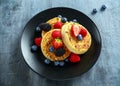 British Crumpets breakfast with blueberries, strawberries, blackberries, raspberries drizzled with icing sugar Royalty Free Stock Photo