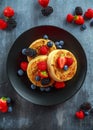 British Crumpets breakfast with blueberries, strawberries, blackberries, raspberries drizzled with icing sugar Royalty Free Stock Photo