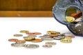 British currency coins open from the piggy bank laid out scattered on white table