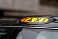 A british london black taxi cab sign with defocused  background Royalty Free Stock Photo