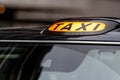 A british london black taxi cab sign with defocused  background Royalty Free Stock Photo