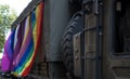 British military truck participates in the Gay Pride Parade, adorned with rainbow and LGBT+ flags.