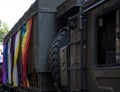 British military vehicle participates in the Gay Pride Parade, adorned with rainbow and LGBT+ flags.