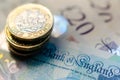 British money. Macro photo of One Pound coins and the British pound banknotes of different denomination