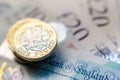 British money. Macro photo of One Pound coins and the British pound banknotes of different denomination