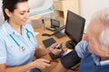 British nurse taking senior man's blood pressure