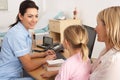 British nurse talking to young child and mother