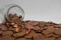 British one and two pence coins falling out of a savings jar