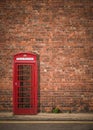 British Phonebox Against Red Brick Wall Royalty Free Stock Photo