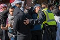 British police officer questions a man in a black hoodie at a Freedom for Palestine protest rally in London