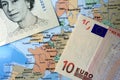 British Pound and Euro notes on European map