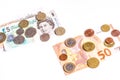 British Pound notes and coins and Euro notes and coins on white Royalty Free Stock Photo