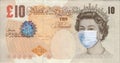 British pound with Queen Elizabeth in a medical mask. Coronovirus COVID-19 pandemic concept. World financial crisis of the economy