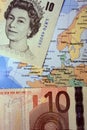 British Pound Sterling and Euro banknotes on European map