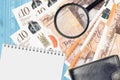 10 British pounds bills and magnifying glass with black purse and notepad. Concept of counterfeit money. Search for differences in Royalty Free Stock Photo