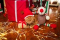 British red cat in Santa hat lying with a Christmas garland near gifts at home. Christmas cat Royalty Free Stock Photo