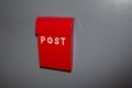 British red post box on grey wall background Royalty Free Stock Photo