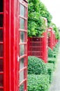 British red telephone box with old fashioned with green tree background in London, United Kingdom Royalty Free Stock Photo