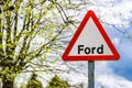 British triangular street sign showing the word Ford against spring background.