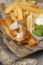 British Traditional crispy Fish and chips with mashed peas, tartar sauce on newspaper. Royalty Free Stock Photo