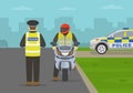 British traffic police officer pulls over a motorcyclist on a city road and checks driver license.