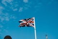 British Union Jack Flag o the United Kingdom waving in the wind with blue clear sky in the background Royalty Free Stock Photo