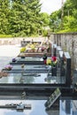 Brittany, France, June 2017. Portrait shot of old Cemetery with black headstones in a row with green trees in background and Royalty Free Stock Photo