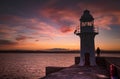 Brixham lighthouse with an orange dusk sky Royalty Free Stock Photo
